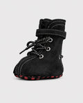 Black dog boots with red soles on a light gray background