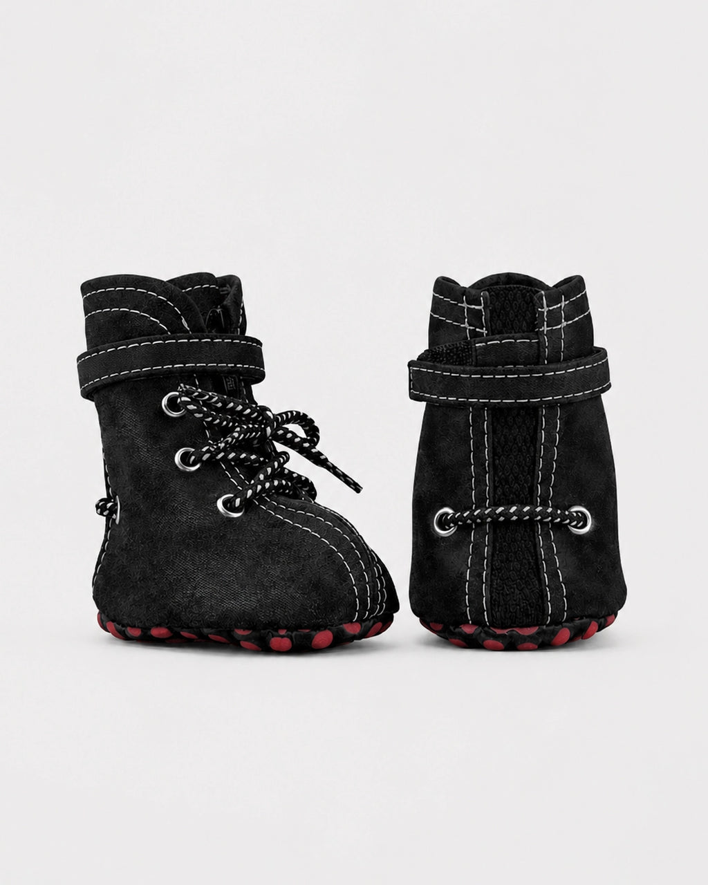 Pair of black dog boots with lace-up design on a light gray background