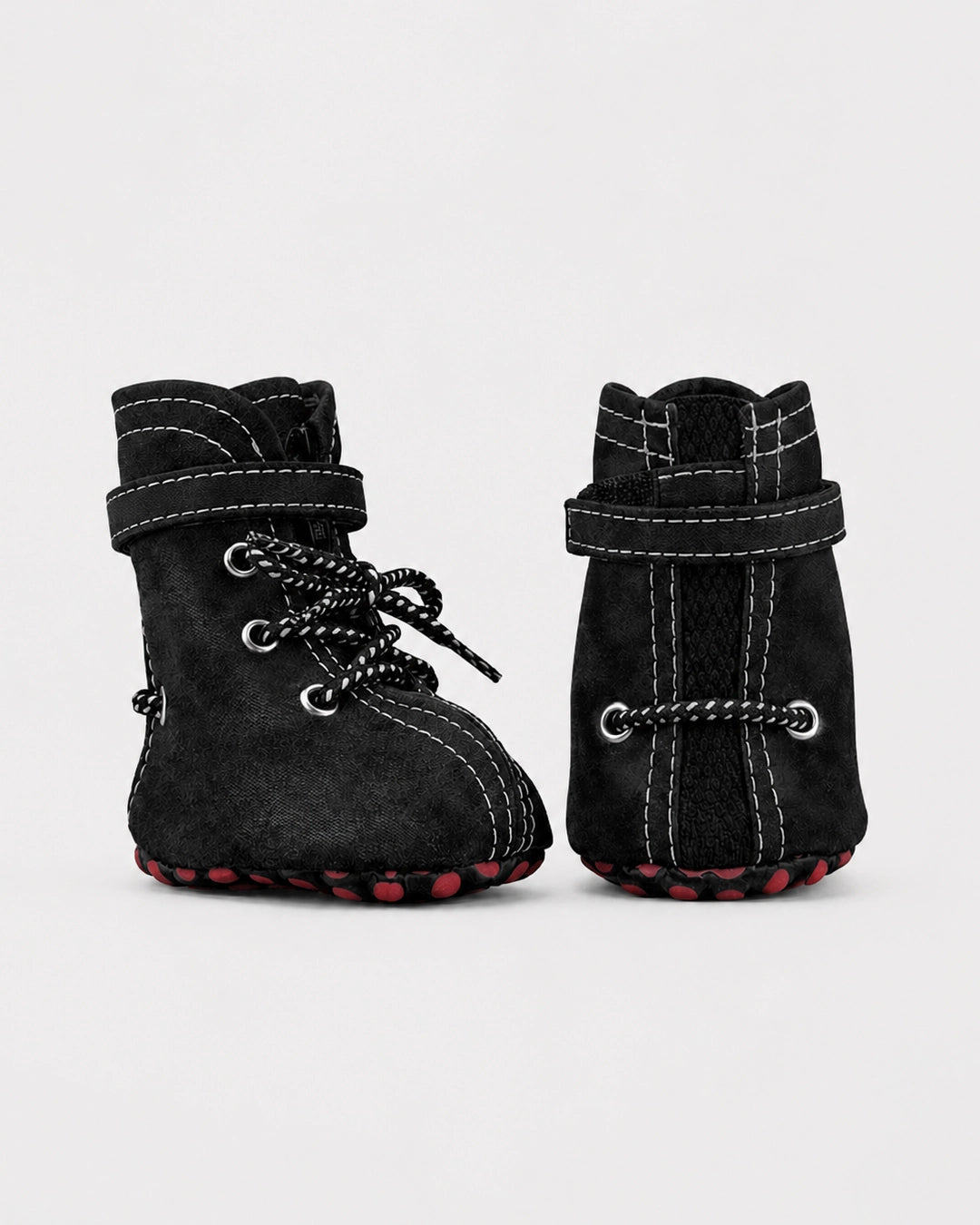 Pair of black dog boots with lace-up design on a light gray background