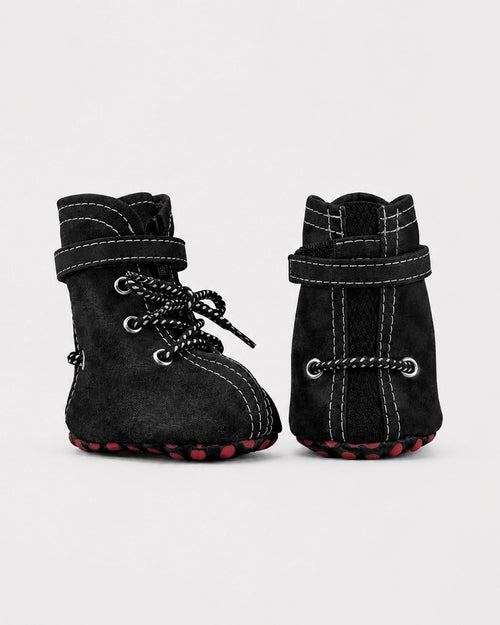 Pair of black dog boots with lace-up design on a light gray background