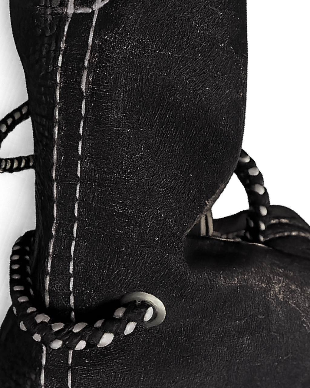 Close-up of a black leather boot with white stitching on a white background