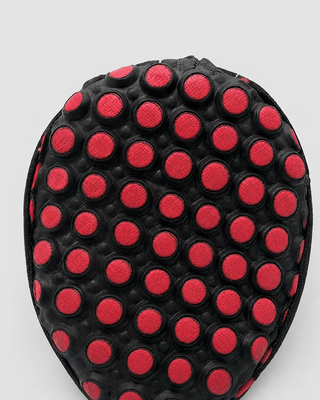Black and red polka dot object on a white background